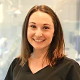 Woman smiling at camera in professional headshot for pediatric dental practice.