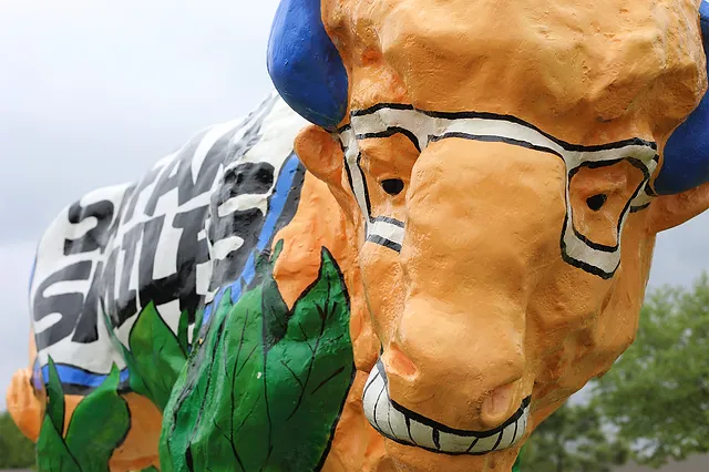 Colorful inflatable dental character balloon featuring a smiling tooth at outdoor event or parade.