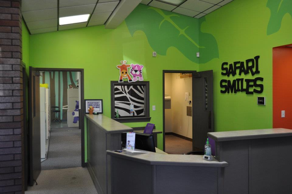 Bright pediatric dental office reception area with safari-themed décor and zebra stripe artwork.